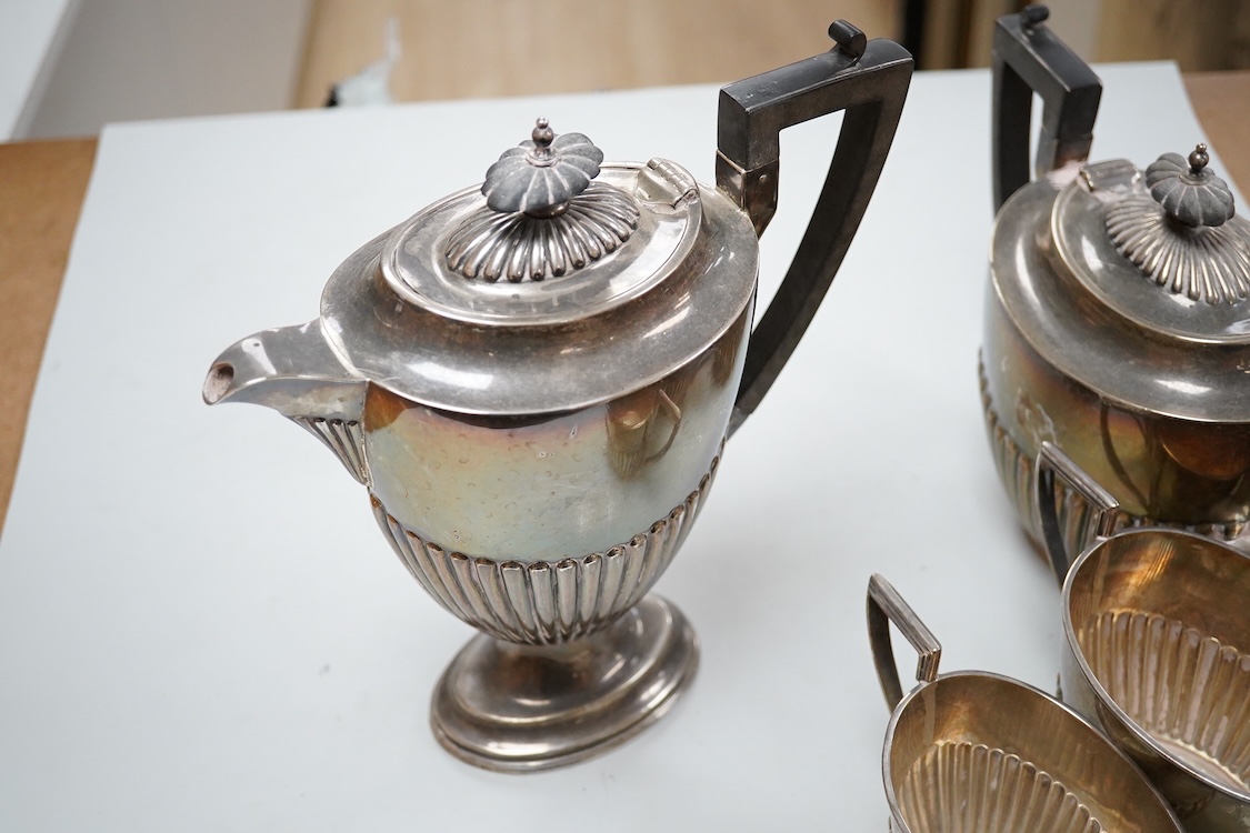 A George V demi fluted silver four piece oval tea set, comprising a teapot, hot water jug, cream jug and sugar bowl, Walker & Hall, 1910/11/12, gross weight 49oz.